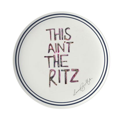 Round white plate with 'This ain't the Ritz' text in colorful letters on a white background