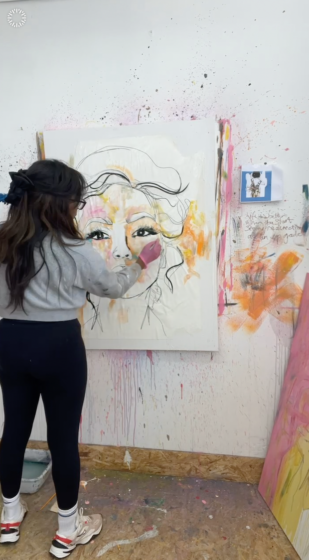 LRM painting a large abstract artwork on a wall.